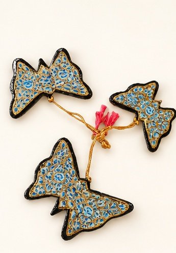 Set of three hand-painted papier mache butterfly ornaments in blue and gold on a golden cord with pink tassel