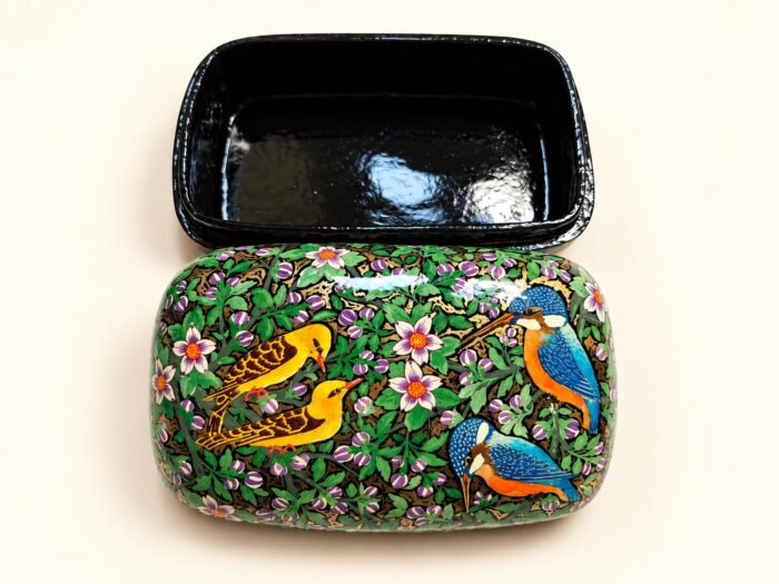 Open 7x4 inch papier mache box hand-painted with golden yellow birds and a blue kingfisher among pink blossoms on green, glossy black lacquered interior