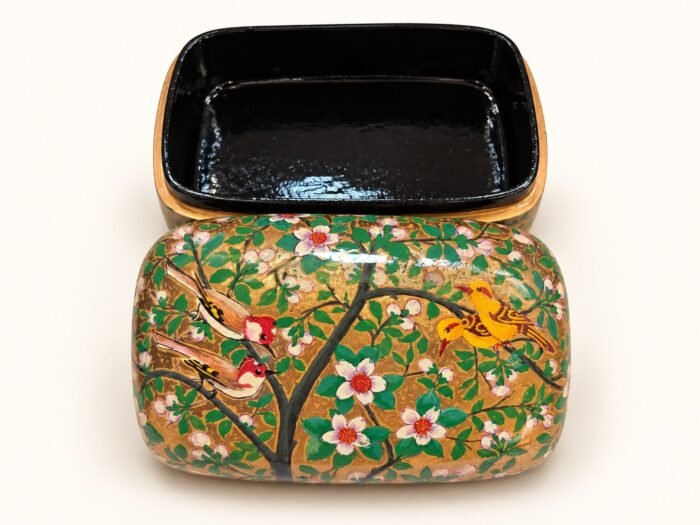 Open 7x4 inch papier mache box hand-painted with red and orange birds on flowering branches and white blossoms on gold and green, glossy black lacquered interior