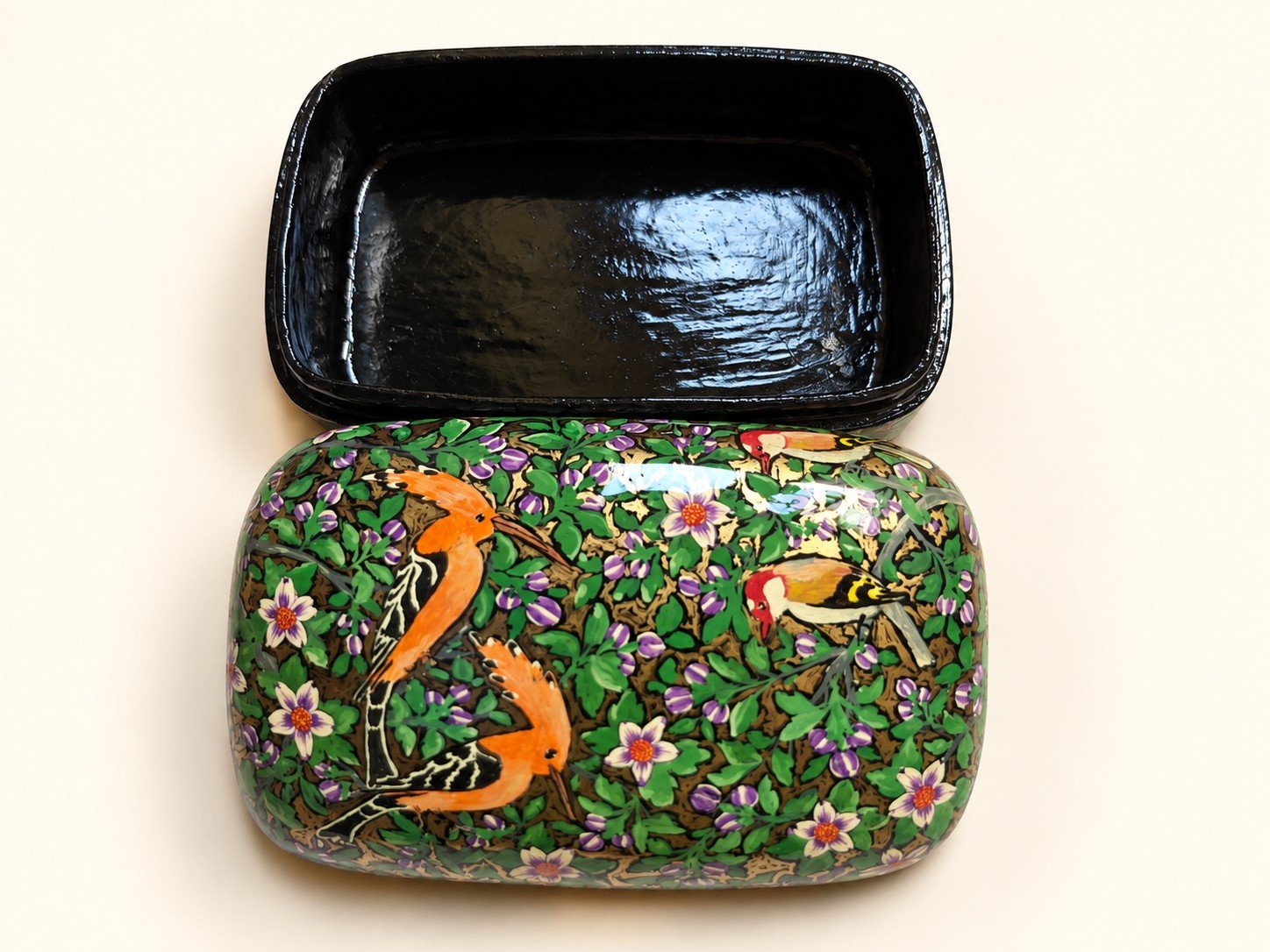 Open 7x4 inch papier mache box hand-painted with orange crested birds among purple buds and white flowers on green, glossy black lacquered interior