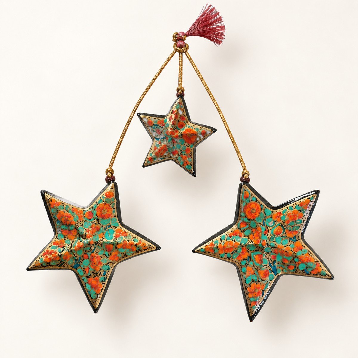 Orange and green papier mache star ornaments hand-painted in Kashmir with orange and green with a black lacquered edge