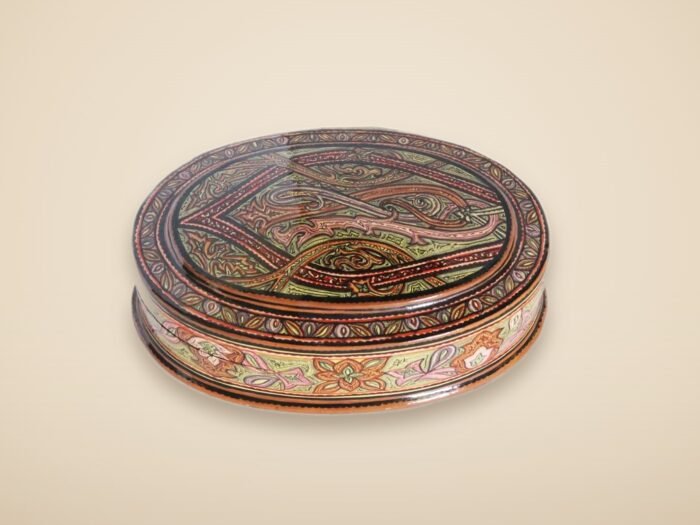 Hand-painted Kashmiri paper mache art in a paisley Mughal design, style 1, on a warm studio background