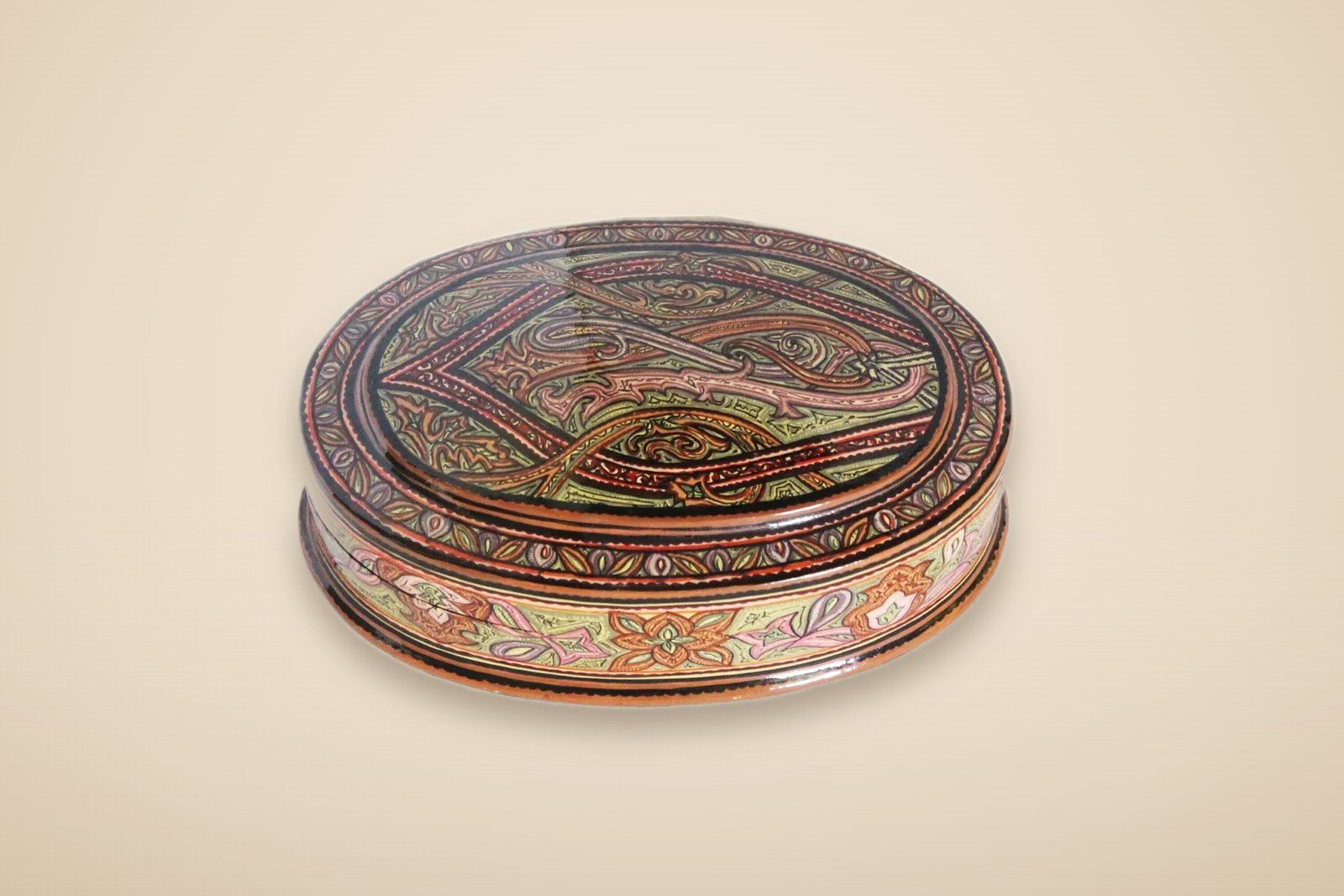 Hand-painted Kashmiri paper mache art in a paisley Mughal design, style 1, on a warm studio background