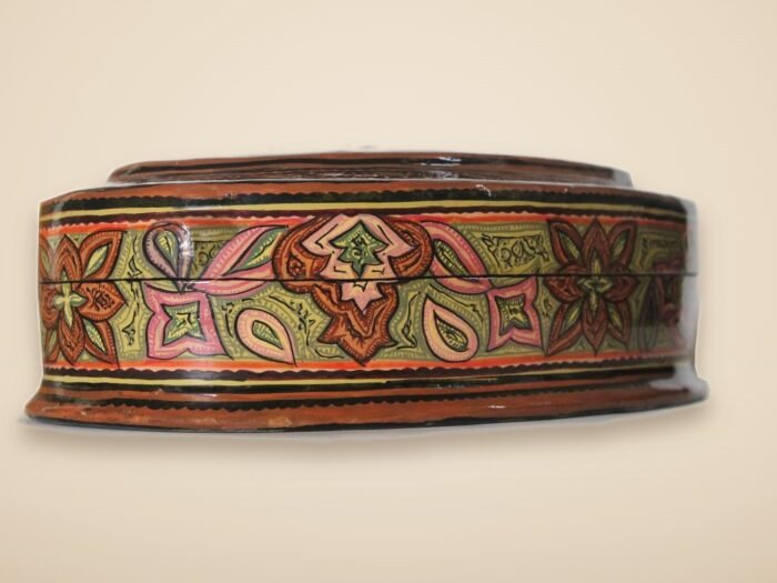 Hand-painted Kashmiri paper mache art in a paisley Mughal design, style 2, on a warm studio background