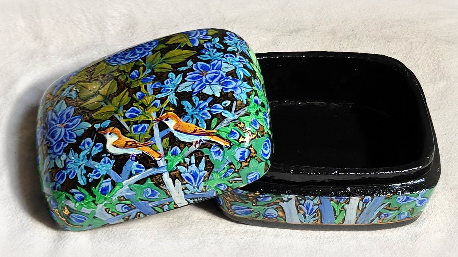 Blue Garden papier mache box No. 2 hand-painted with a pair of perched songbirds among cobalt and sky-blue blossoms with olive leaves, real 24K gold strokes in the background, with the lid off, showing the glossy black lacquered interior