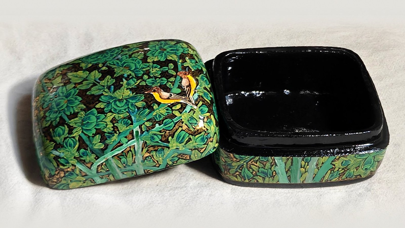 Emerald Garden papier mache box No. 1 hand-painted with a pair of golden songbirds among emerald and leaf-green flowers, real 24K gold strokes in the background, with the lid off, showing the glossy black lacquered interior
