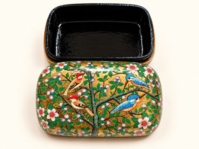 Open 7x4 inch papier mache box hand-painted with red and blue birds on flowering branches and white blossoms on gold and green, glossy black lacquered interior
